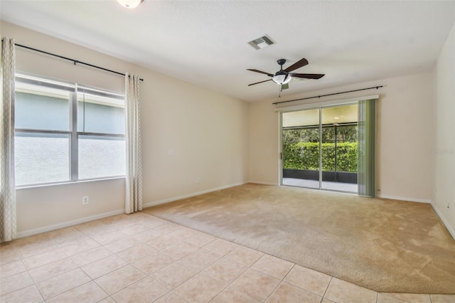 empty room featuring ceiling fan and light colored carpet