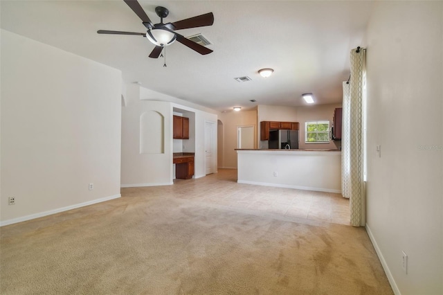 unfurnished living room with ceiling fan and light colored carpet