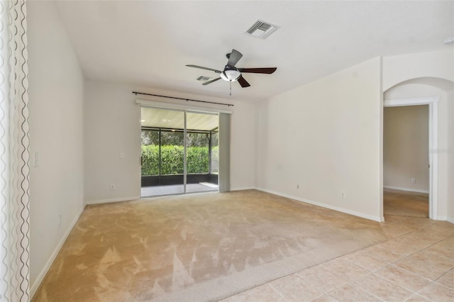 spare room featuring light carpet and ceiling fan