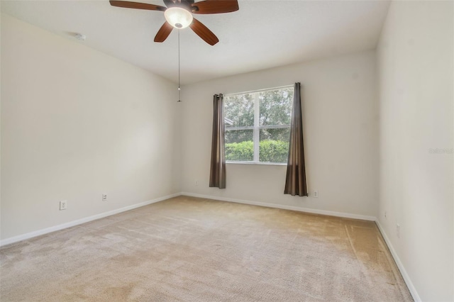 spare room with ceiling fan and light colored carpet