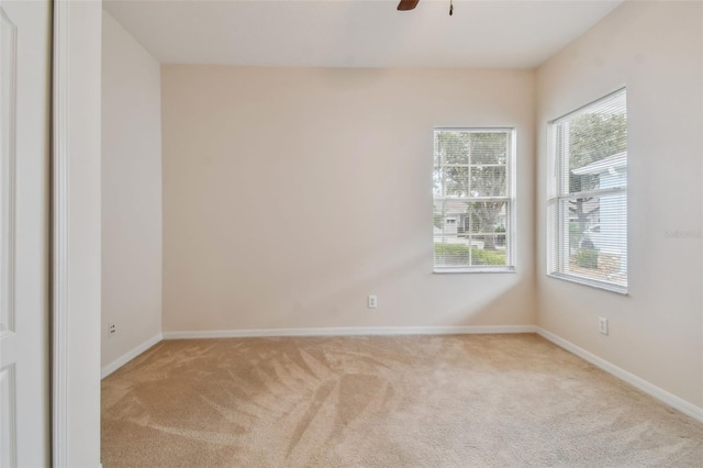 carpeted spare room with ceiling fan