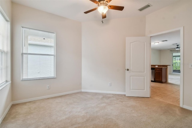 spare room featuring light carpet and ceiling fan