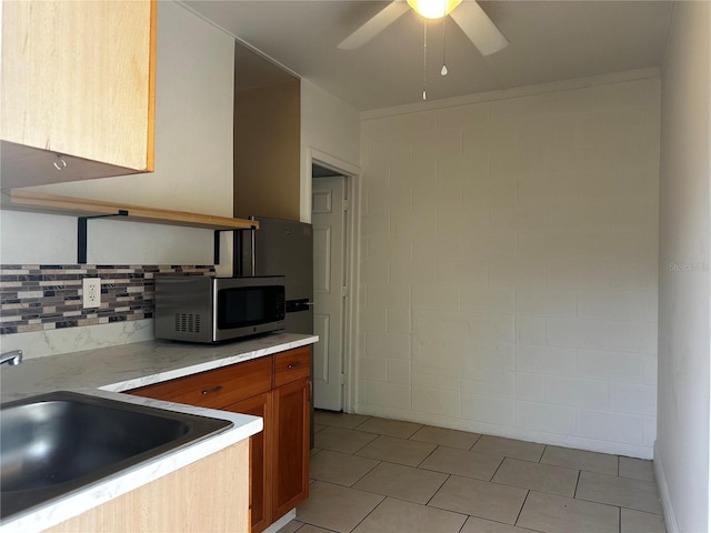 kitchen featuring backsplash, sink, and ceiling fan