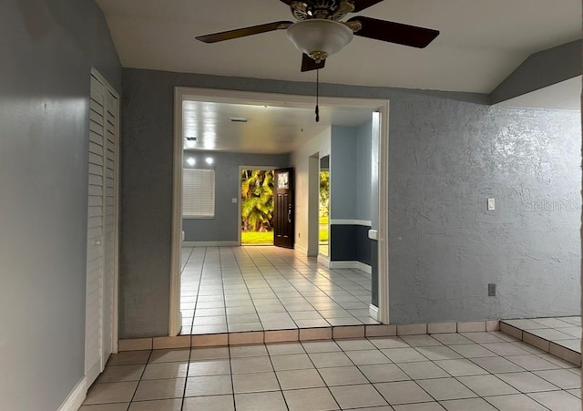 tiled spare room with ceiling fan