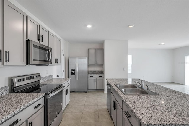 kitchen with an island with sink, stainless steel appliances, sink, and a healthy amount of sunlight