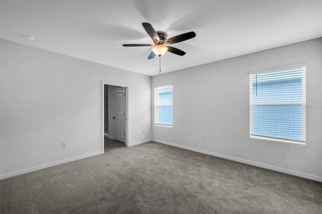 carpeted spare room featuring ceiling fan