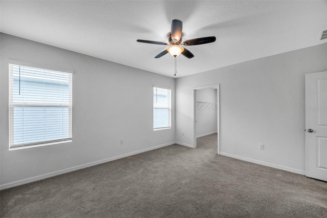 carpeted spare room featuring ceiling fan