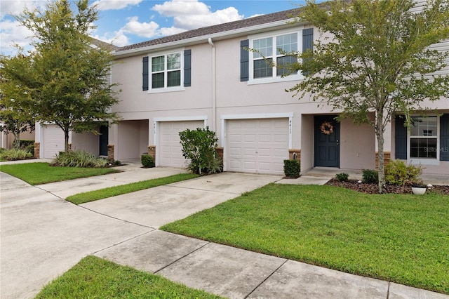 townhome / multi-family property with a front yard and a garage