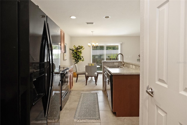 kitchen with a notable chandelier, decorative light fixtures, light tile patterned floors, sink, and appliances with stainless steel finishes