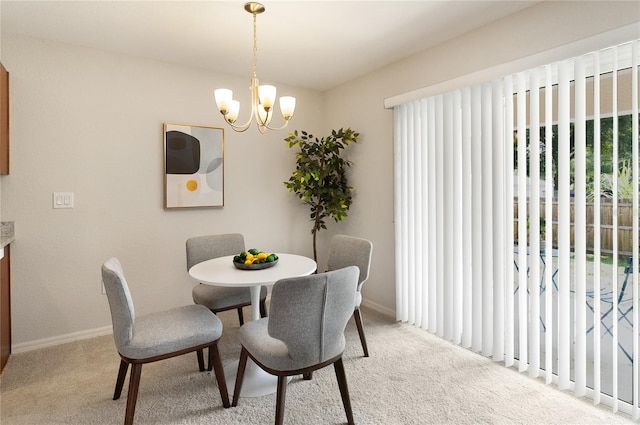 dining space with carpet and an inviting chandelier