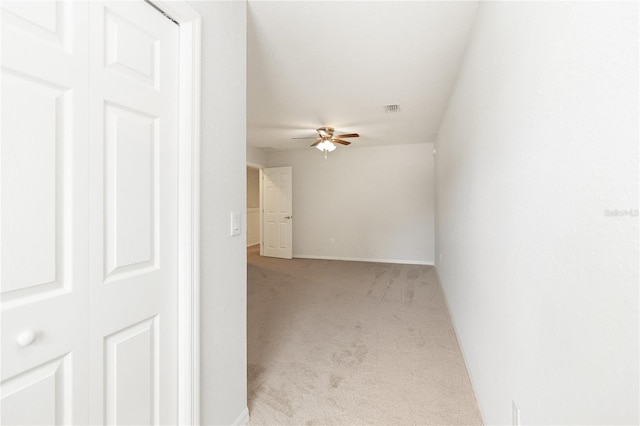 interior space featuring light colored carpet and ceiling fan