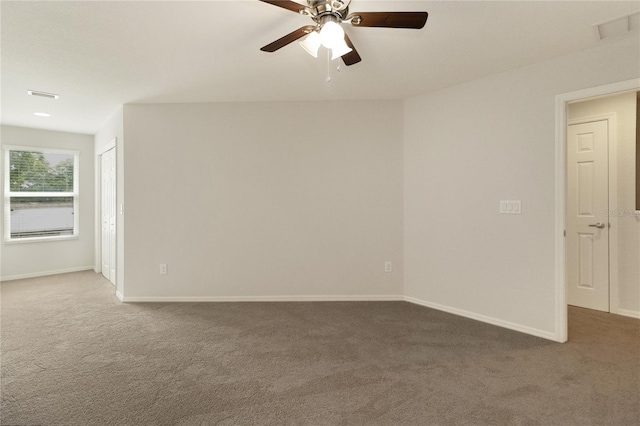 carpeted spare room featuring ceiling fan