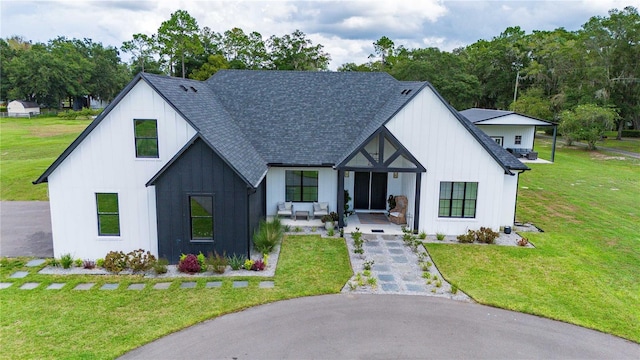 modern farmhouse style home featuring covered porch and a front lawn