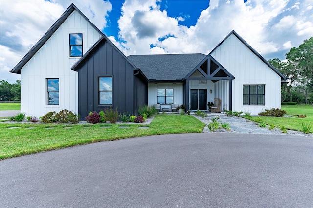 modern farmhouse style home with a front yard