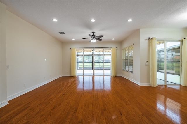 empty room featuring a textured ceiling, hardwood / wood-style flooring, and ceiling fan