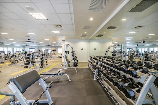 gym with hardwood / wood-style floors, a paneled ceiling, and ceiling fan