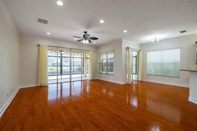 unfurnished room with ceiling fan, plenty of natural light, and hardwood / wood-style floors