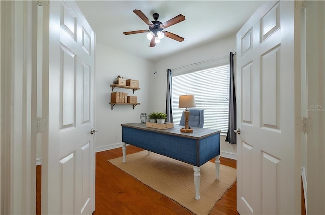 home office with ceiling fan and dark hardwood / wood-style floors