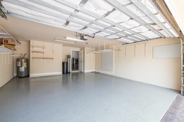 garage with washing machine and clothes dryer, water heater, and a garage door opener