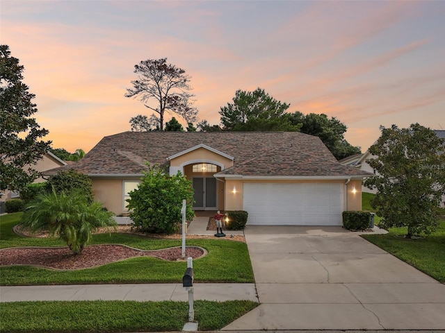 ranch-style home featuring a yard and a garage