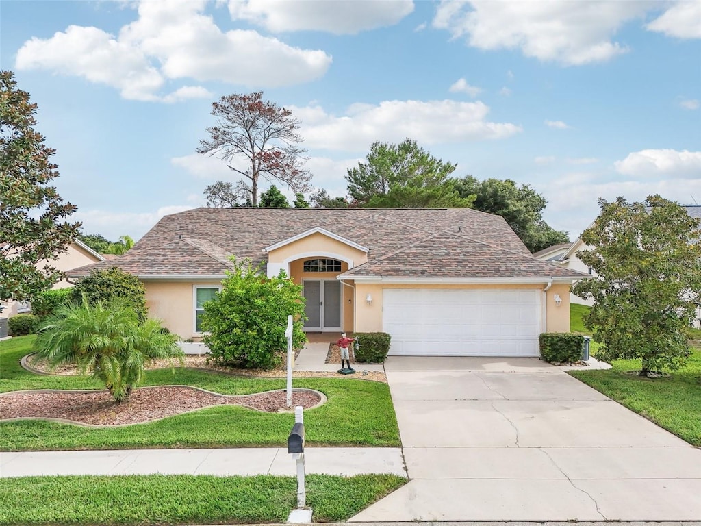 single story home featuring a garage and a front lawn