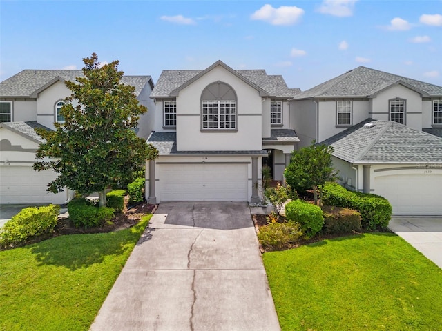 traditional-style house with a front yard, an attached garage, stucco siding, a shingled roof, and concrete driveway