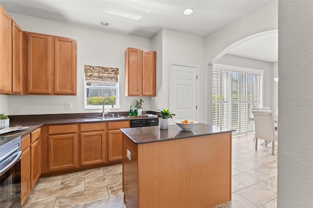 kitchen featuring a kitchen island, a wealth of natural light, dishwashing machine, and sink