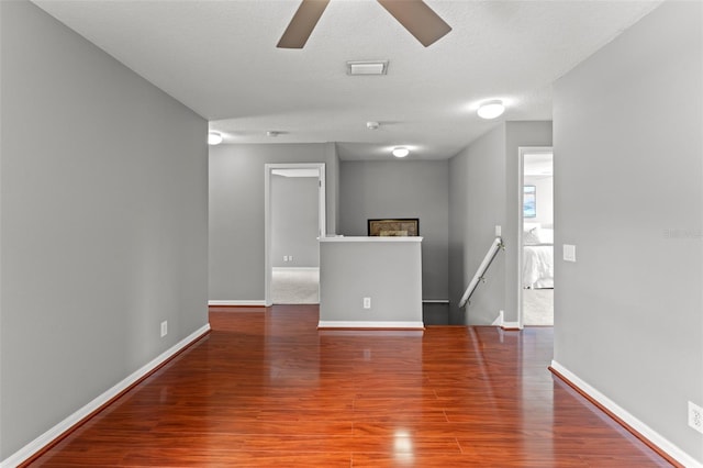 empty room with a textured ceiling, ceiling fan, and hardwood / wood-style floors