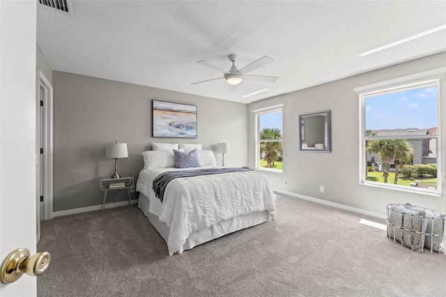 bedroom featuring ceiling fan, a textured ceiling, and carpet floors