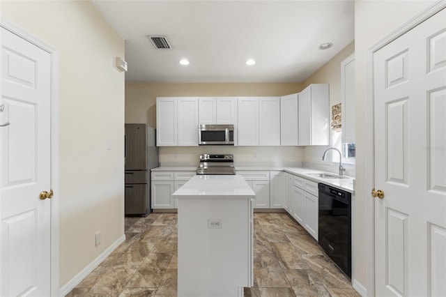 kitchen with white cabinets, a center island, stainless steel appliances, and sink