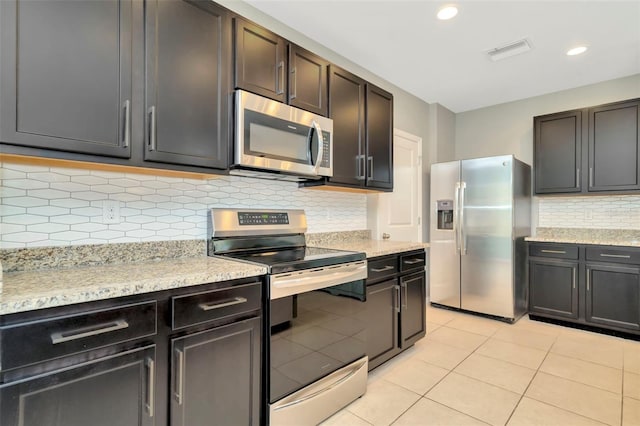 kitchen featuring dark brown cabinetry, backsplash, and appliances with stainless steel finishes