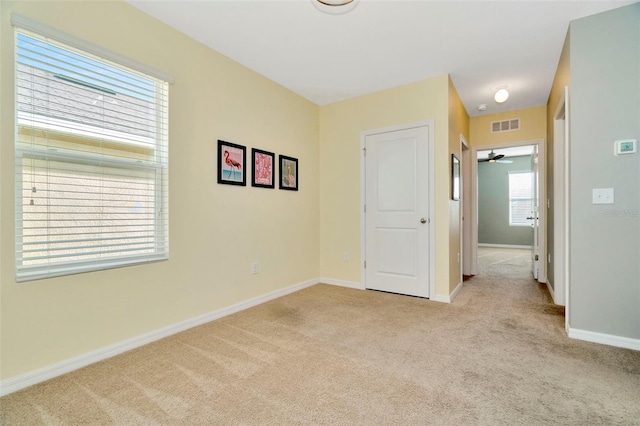 unfurnished room featuring ceiling fan and light colored carpet