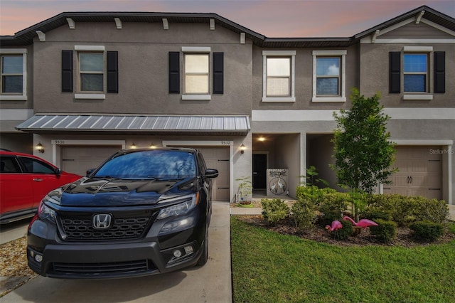 multi unit property with stucco siding and an attached garage