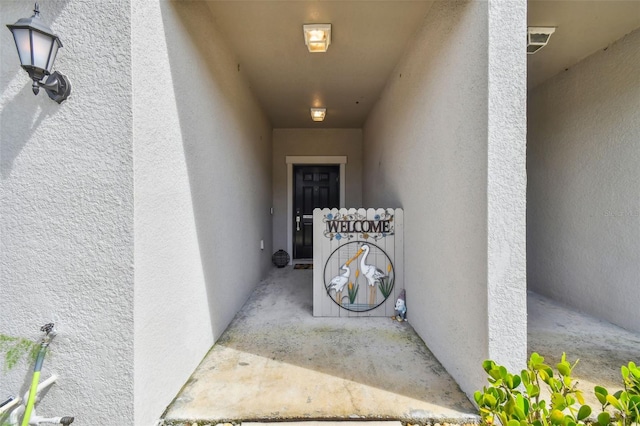 doorway to property featuring stucco siding