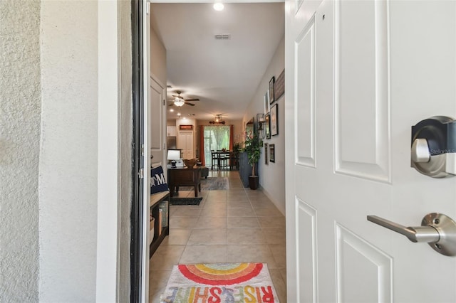hallway featuring light tile patterned floors and visible vents