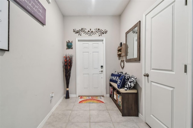 foyer entrance featuring light tile patterned flooring and baseboards