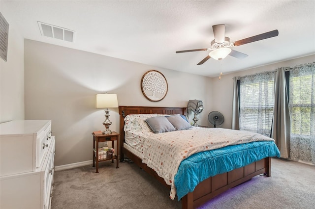 bedroom featuring visible vents, baseboards, a ceiling fan, and light carpet