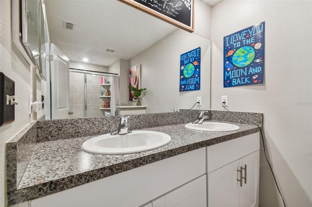 full bathroom featuring double vanity, visible vents, a sink, and a stall shower