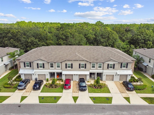 multi unit property with driveway, a garage, and stucco siding