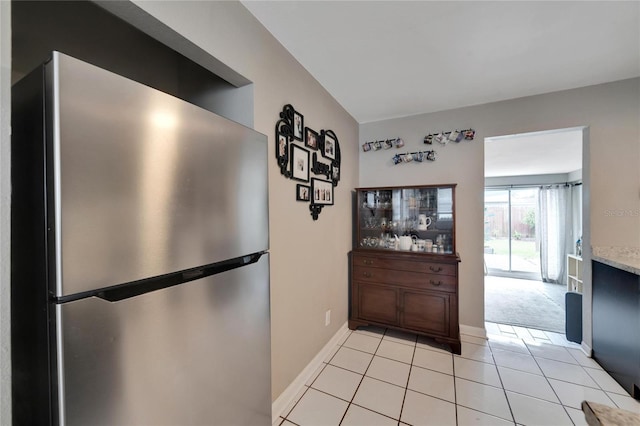 kitchen with stainless steel fridge and light tile patterned flooring