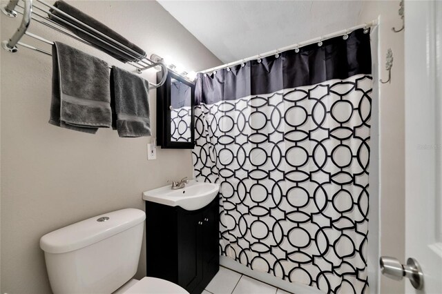 bathroom with tile patterned floors, walk in shower, vanity, and toilet