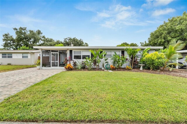 ranch-style house featuring a sunroom and a front yard