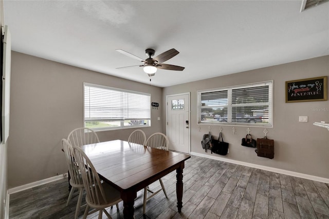 dining space featuring ceiling fan and dark wood-type flooring