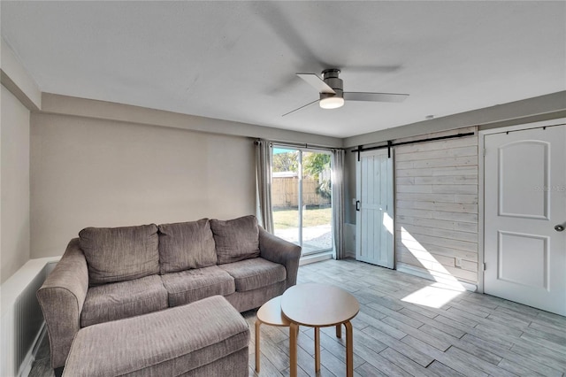 living room featuring ceiling fan and a barn door