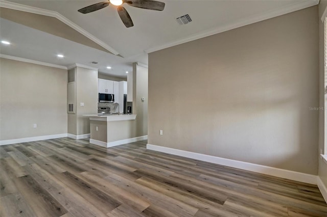 unfurnished living room with hardwood / wood-style floors, ceiling fan, ornamental molding, and vaulted ceiling