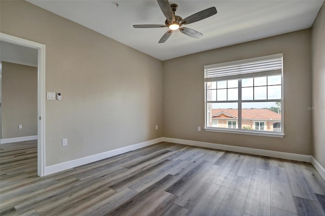 empty room with ceiling fan and light hardwood / wood-style floors