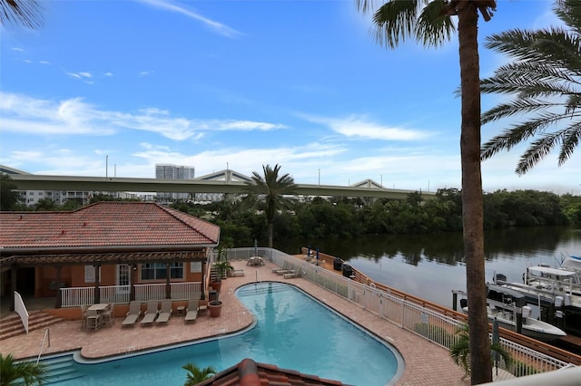 view of swimming pool featuring a water view and a patio