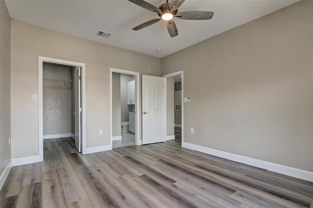 unfurnished bedroom featuring ceiling fan, a closet, and light hardwood / wood-style flooring