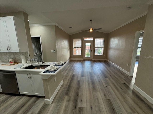 kitchen featuring crown molding, open floor plan, white cabinets, a sink, and dishwashing machine