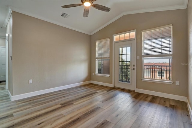 empty room with visible vents, a ceiling fan, vaulted ceiling, wood finished floors, and baseboards